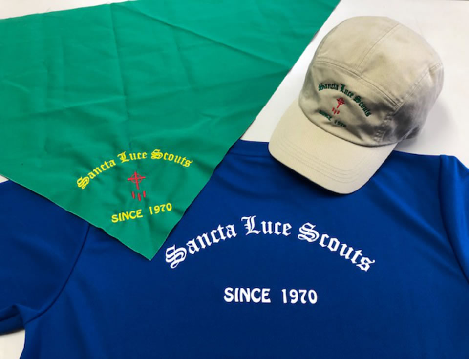創立５０周年の記念品ブルーのTシャツとロゴが入ったグリーンのスカーフと薄い肌色のキャップ